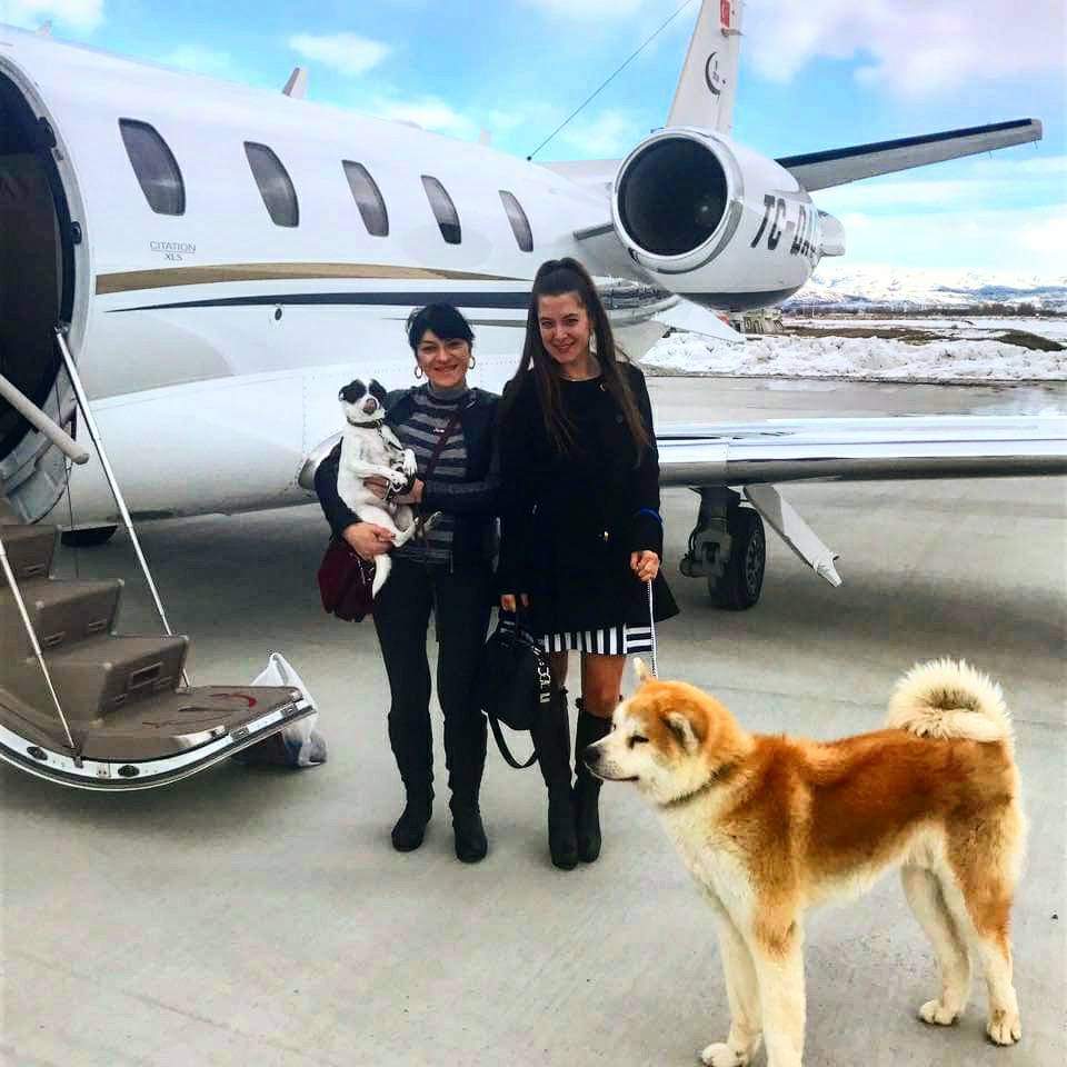Köpekleriyle özel uçak önünde memnun müşteriler